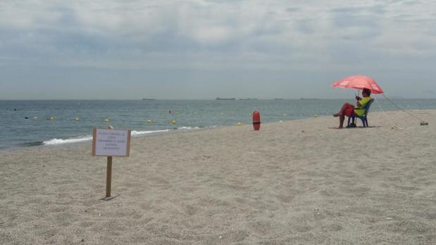 Imagen de la playa de El Burgo, con el cartel que prohíbe el baño
