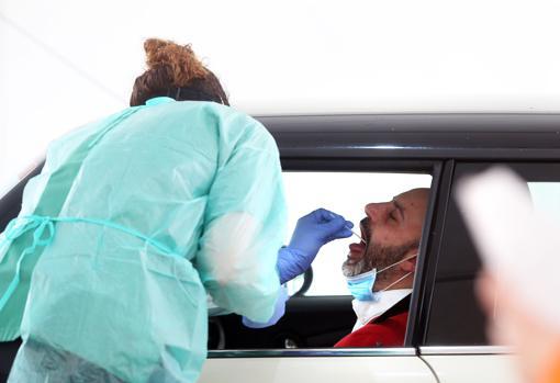 Un trabajador de la salud que realiza una prueba de control de coronavirus en un conductor