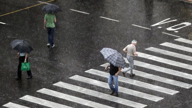 Varias personas se protegen de la lluvia en una imagen de archivo tomada en el centro de Valencia