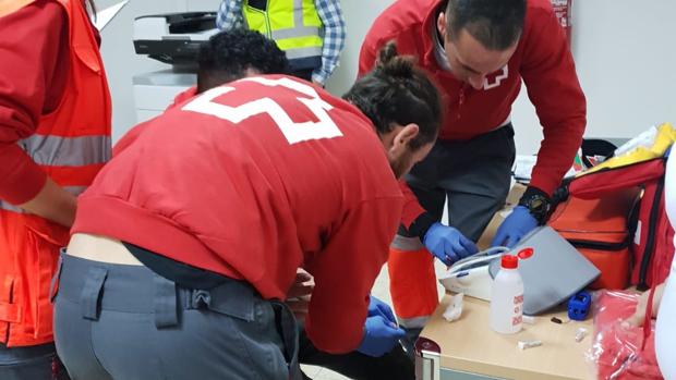 Efectivos de Cruz Roja atendiendo a uno de los inmigrantes