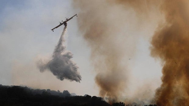 Un hidroavión suelta agua sobre las llamas en e incendio de Cadalso de los Vidrios y Cenicientos