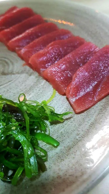 Sashimi de atún acompañado de algas