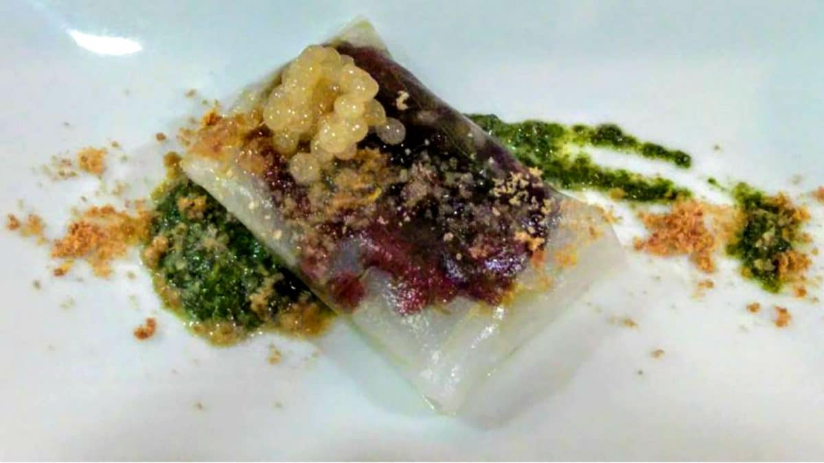 Sorpresa: Atún sobre fondo de lechuga de Mar, envuelto en pasta de arroz con cebolla roja confitada en vinagre de módena,alga Wakame con esterificación de Vino Palo Cortado y virutas de mojama