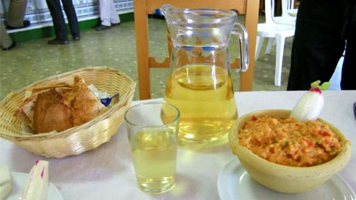 Una jarra de mosto Domi junto a un plato de ajo campero.