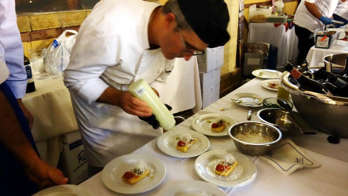 En el stand de Romerijo culminando la tapa de langostinos de estero ahumados sobre esponja de pan