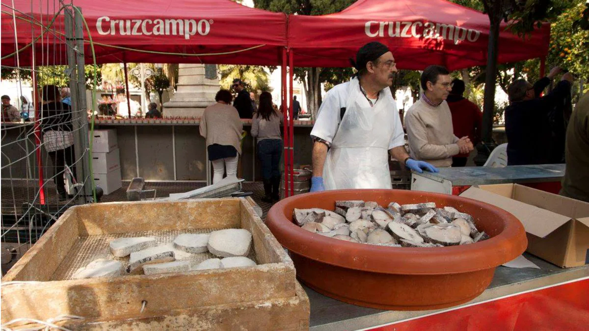 Miembros de la Peña La Estrella preparan el pescado para freirlo. | Cedida.