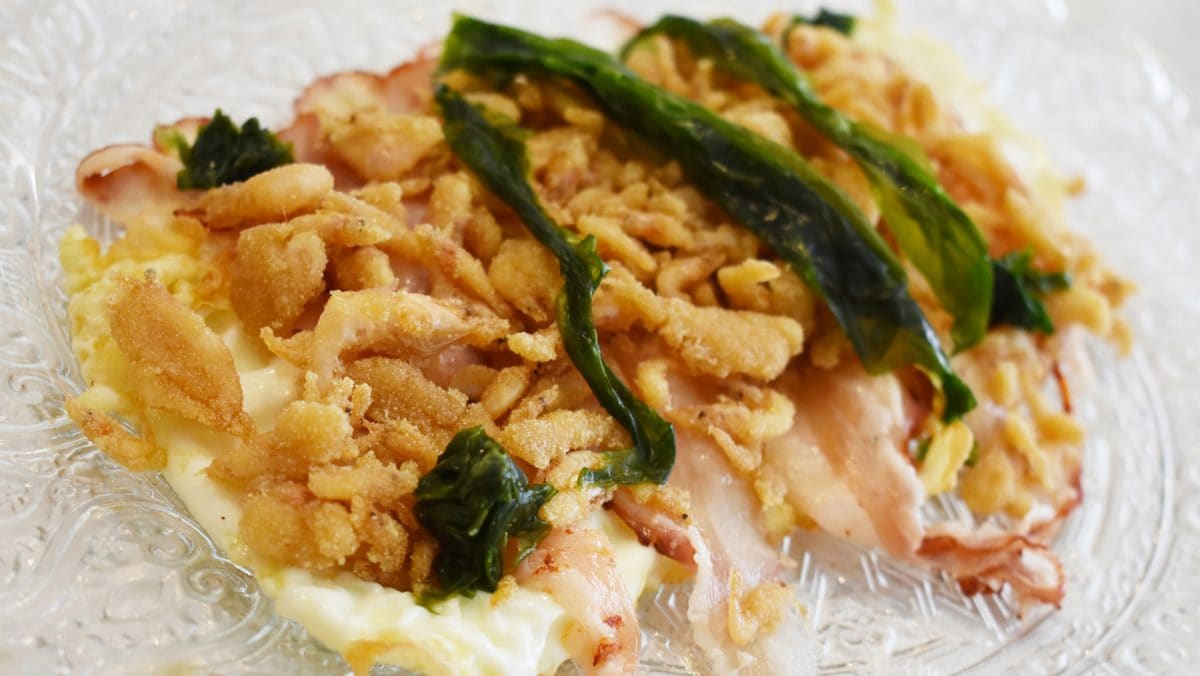 Huevos camperos con papada, crujiente de camarón y lechuga de mar.