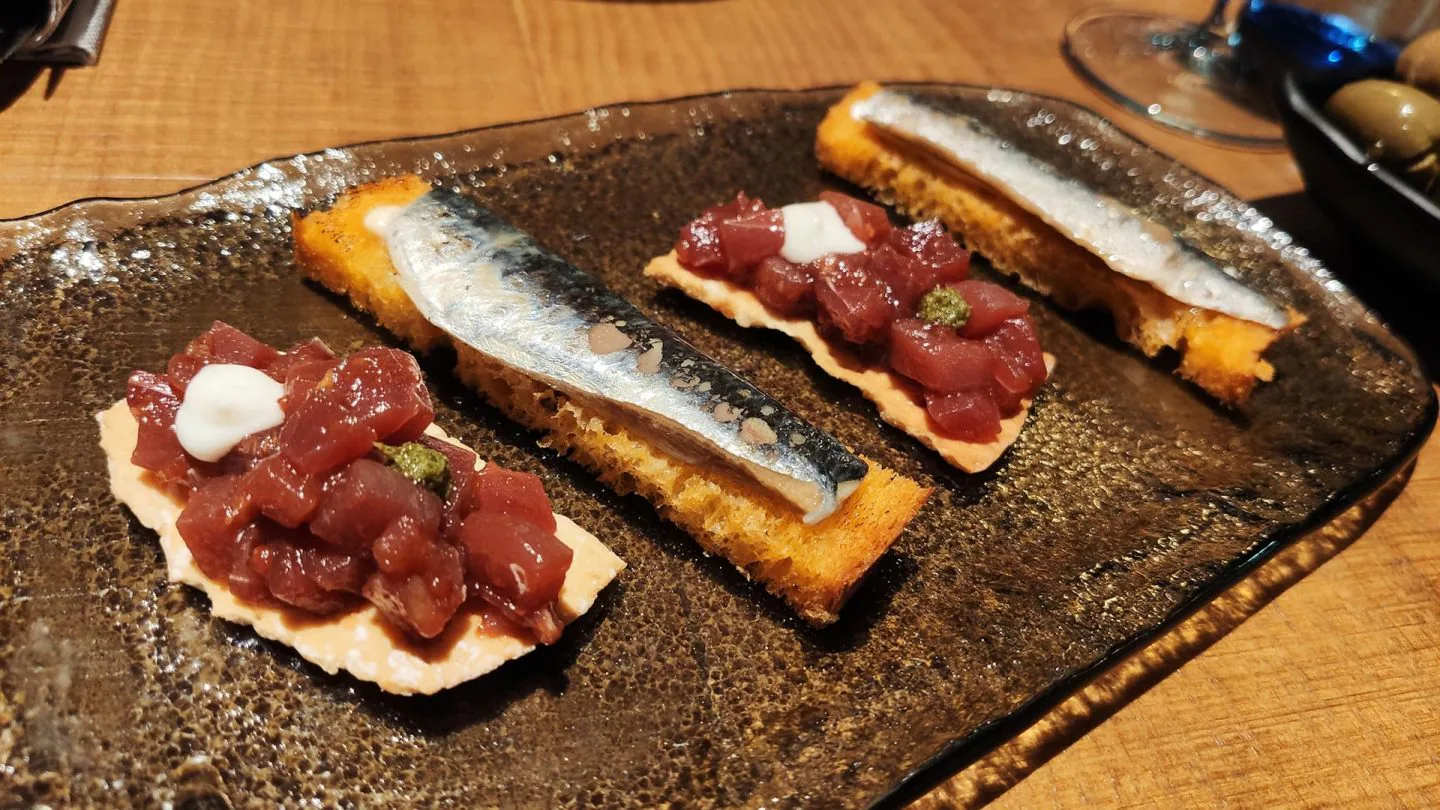 Tosta de tartar de atún, queso payoyo y aceituna. Brioche de pimientos asados y sardina marinada.
