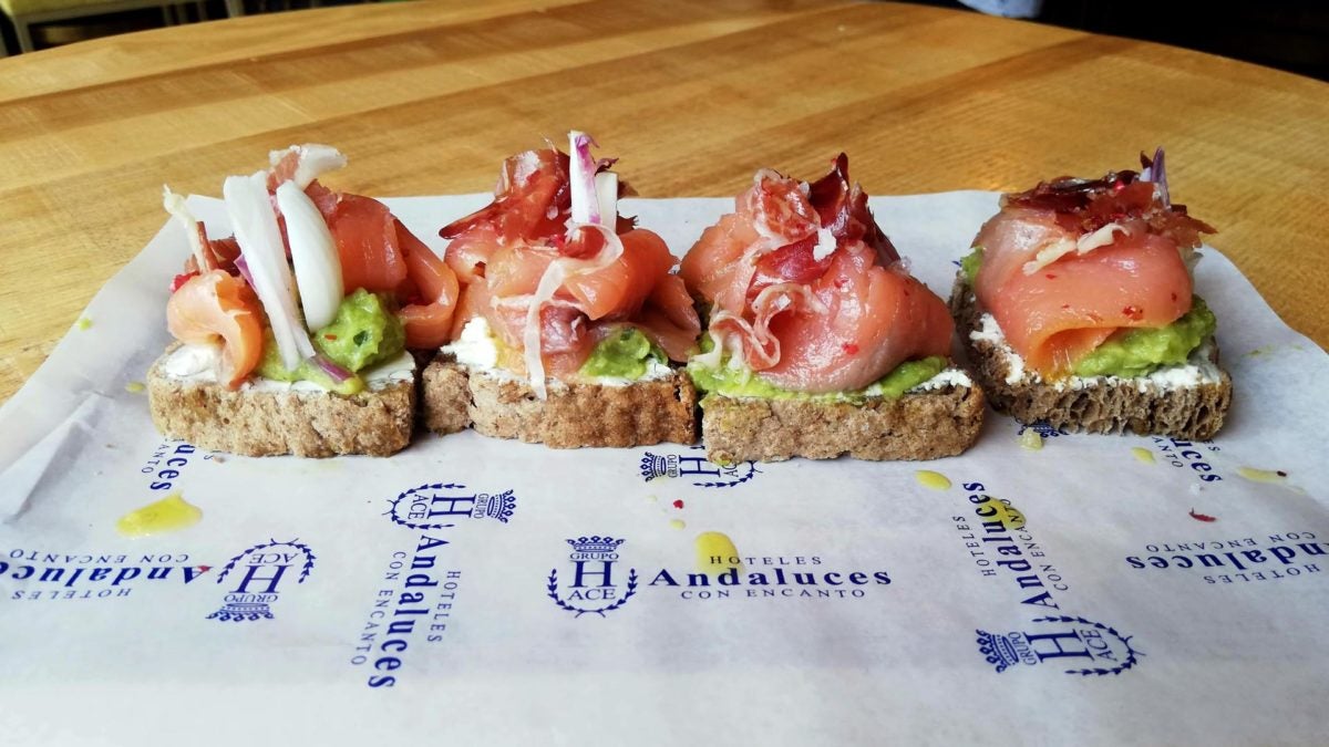 Tosta de salmón, guacamole, tomate seco y jamón ibérico.