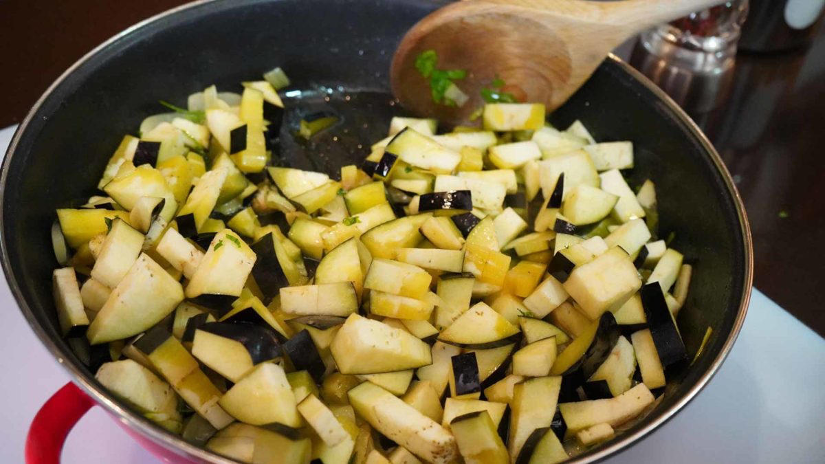 Las berenjenas cortadas a daditos se incorporan al sofrito.