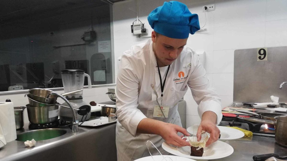 Isaac Benítez, de la Escuela de Hostelería de San Roque, dando los últimos toques a su bizcocho.