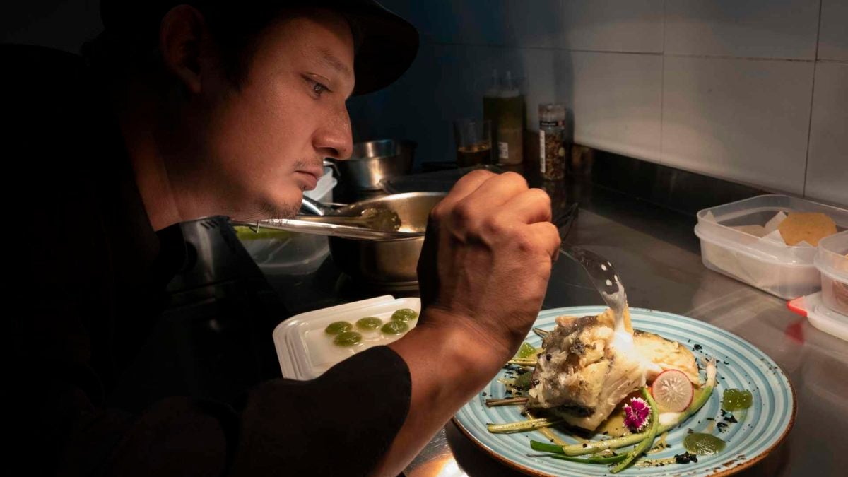 Elesban, dando los últimos toques a un plato en la cocina.