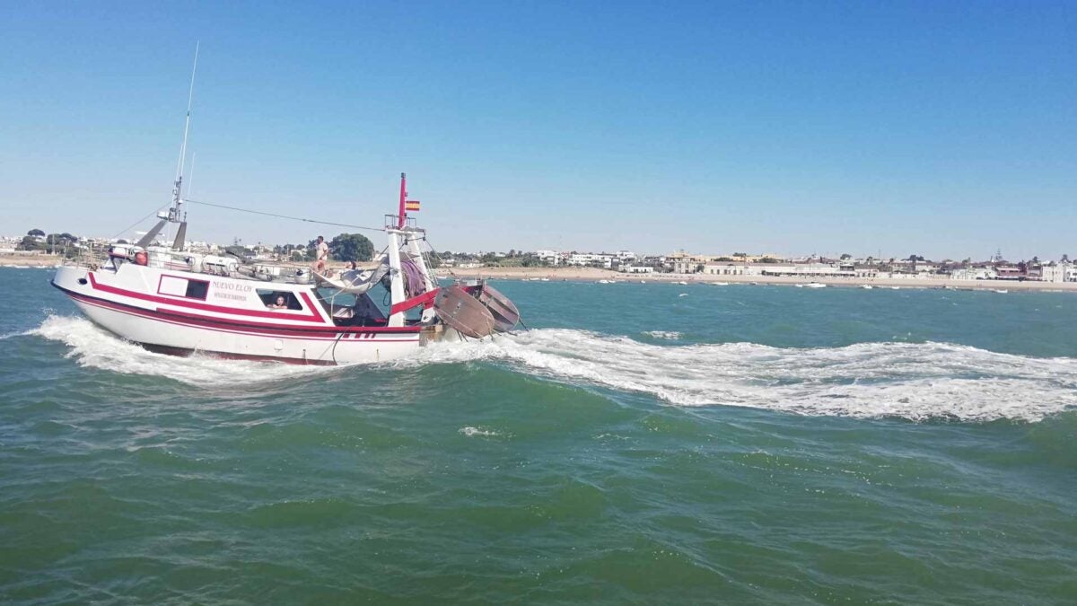 Un pesquero regresando a puerto, con Bajo de Guía al fondo.