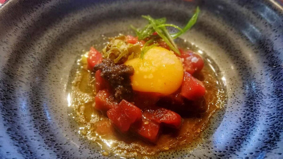 Tartar de atún con yema de huevo de caserío, trufa y vinagreta de ajetes.