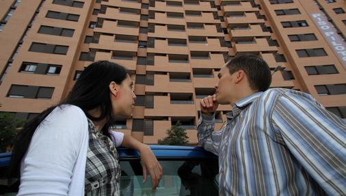 Una pareja ante un bloque de viviendas
